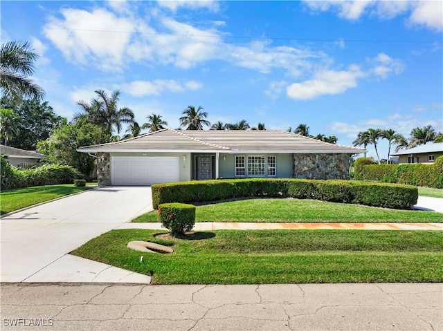 ranch-style home with a garage, concrete driveway, stone siding, a front lawn, and stucco siding