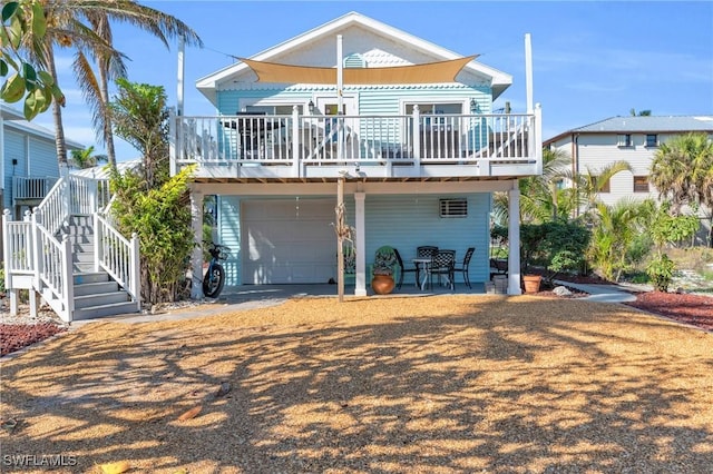 rear view of property with a garage and stairway