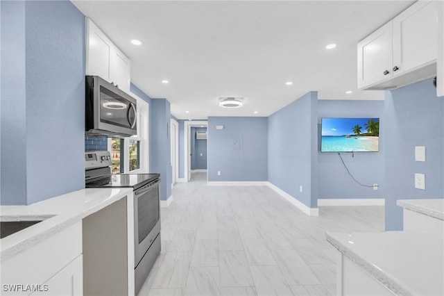 kitchen featuring baseboards, appliances with stainless steel finishes, white cabinetry, and recessed lighting