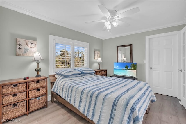 bedroom with light wood finished floors, a ceiling fan, and crown molding