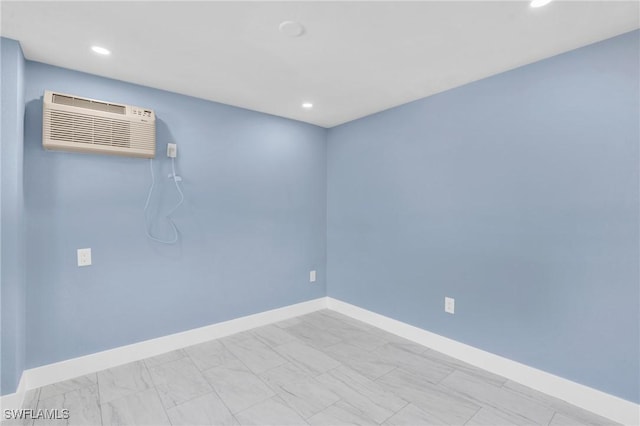 spare room featuring baseboards, an AC wall unit, and recessed lighting