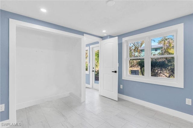 unfurnished room featuring recessed lighting and baseboards