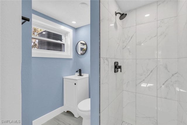 full bathroom featuring toilet, a sink, baseboards, marble finish floor, and tiled shower