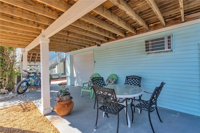 view of patio featuring a garage and outdoor dining space