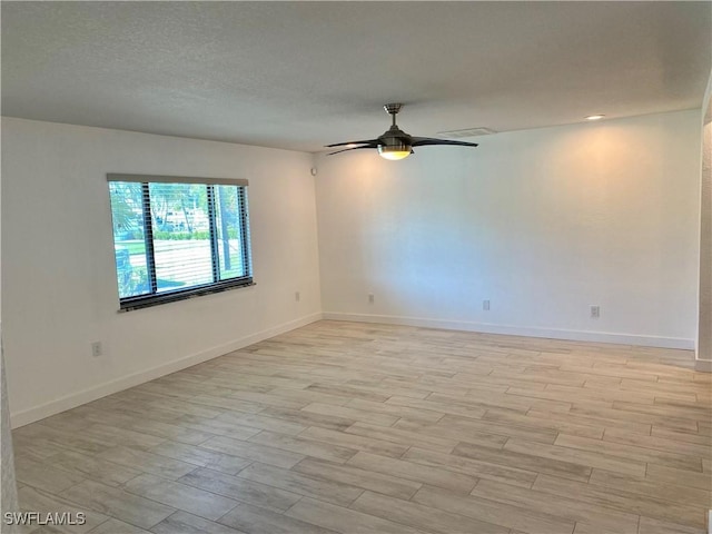 81 Cardinal Dr, North Fort Myers, FL 33917 - spare room with a ceiling fan, light wood-type flooring, a textured ceiling, and baseboards