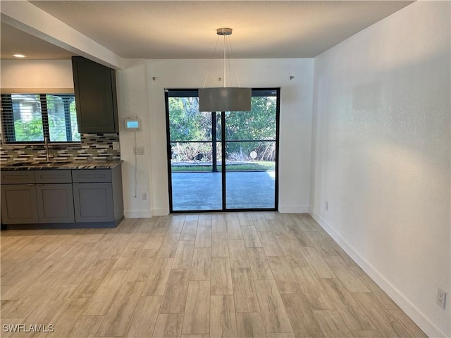 81 Cardinal Dr, North Fort Myers, FL 33917 - unfurnished dining area with light wood-style floors, a sink, and baseboards