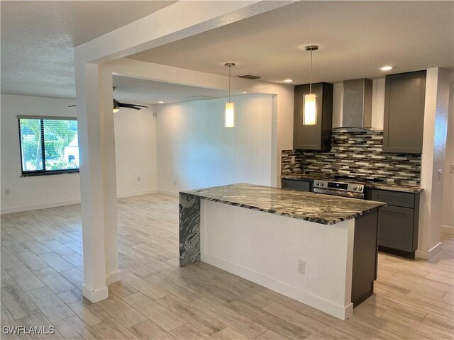 81 Cardinal Dr, North Fort Myers, FL 33917 - kitchen with tasteful backsplash, light wood-style floors, dark stone countertops, stainless steel range with electric cooktop, and wall chimney range hood