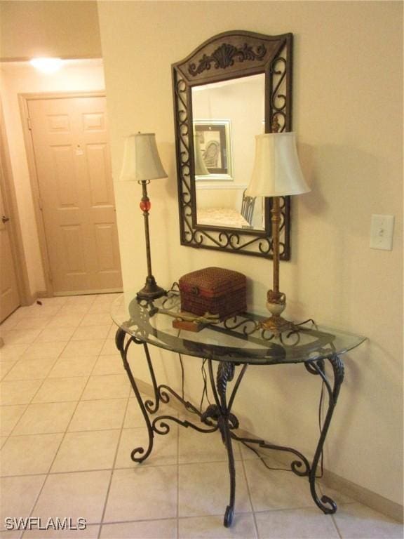 hall featuring light tile patterned floors and baseboards