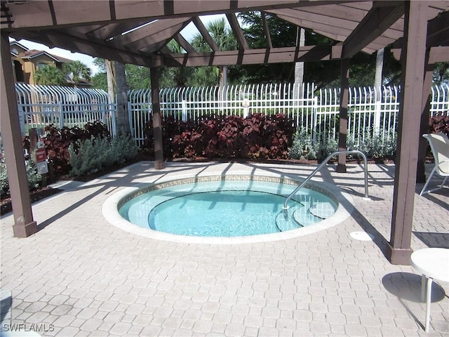 view of swimming pool with a community hot tub, a patio area, fence, and a pergola