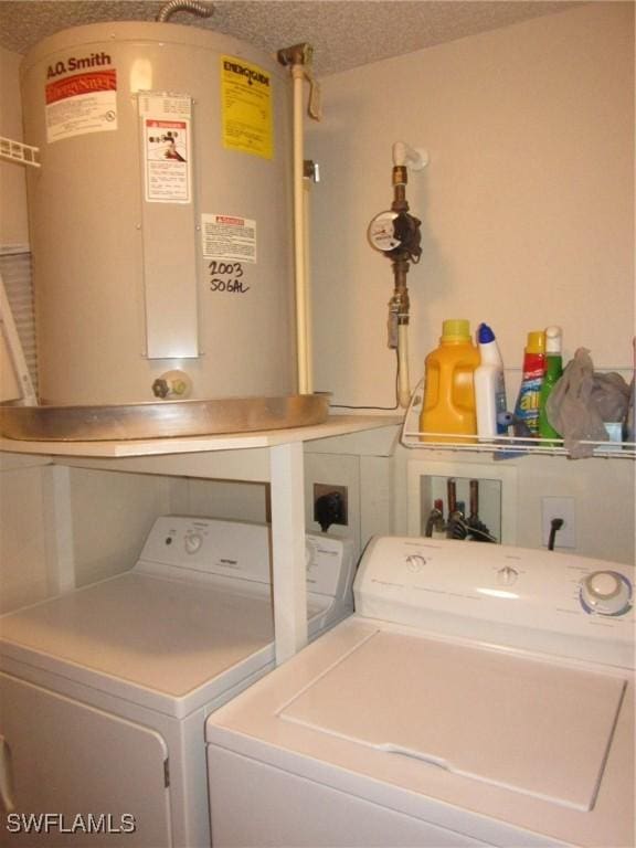 laundry room featuring laundry area, washer and clothes dryer, a textured ceiling, and electric water heater