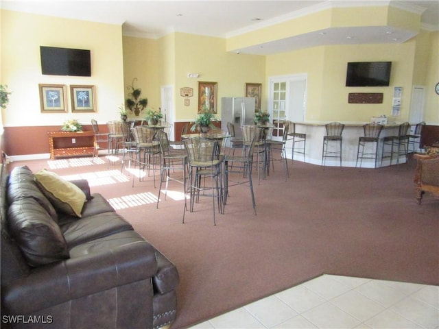 tiled living area with carpet flooring and crown molding