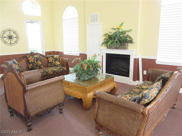carpeted living room with visible vents and a fireplace