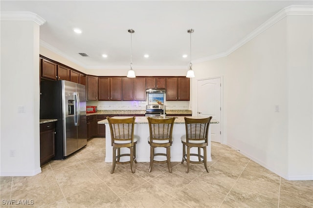 kitchen featuring a kitchen breakfast bar, hanging light fixtures, appliances with stainless steel finishes, an island with sink, and crown molding