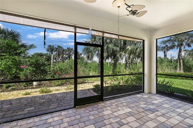 unfurnished sunroom with a ceiling fan