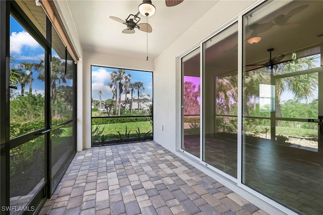 unfurnished sunroom featuring ceiling fan