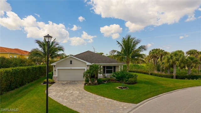 view of front of property featuring a front lawn, decorative driveway, and an attached garage