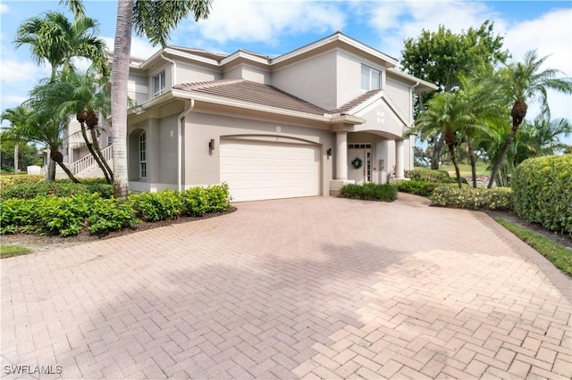 view of front facade with decorative driveway and stucco siding