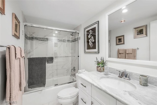 bathroom with toilet, bath / shower combo with glass door, and vanity