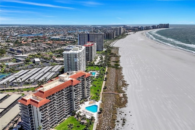 birds eye view of property featuring a view of city, a water view, and a beach view