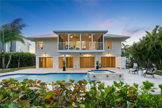 back of property with metal roof, a patio area, fence, and a ceiling fan