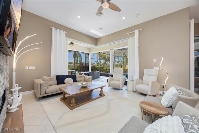 living room with light tile patterned floors, a ceiling fan, recessed lighting, and baseboards