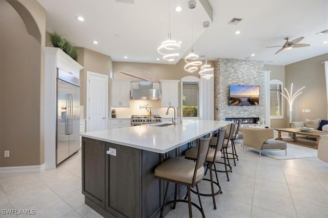 kitchen with stainless steel built in fridge, visible vents, a sink, open floor plan, and white cabinetry