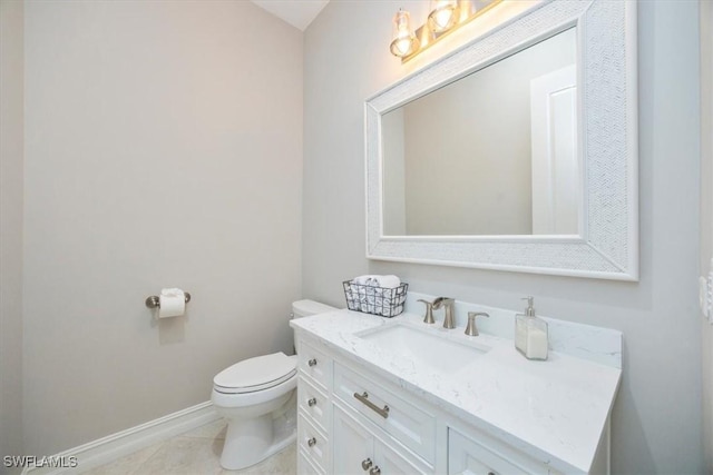 half bathroom with tile patterned floors, baseboards, toilet, and vanity