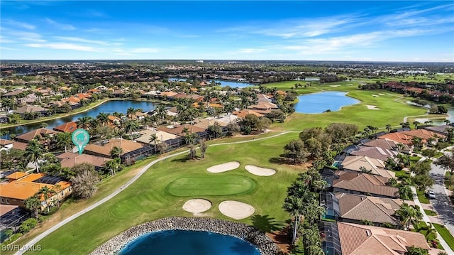 drone / aerial view featuring view of golf course, a water view, and a residential view