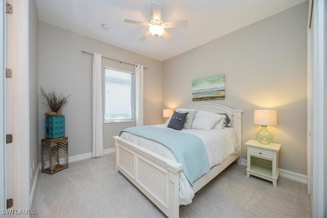 bedroom featuring baseboards, light colored carpet, and a ceiling fan