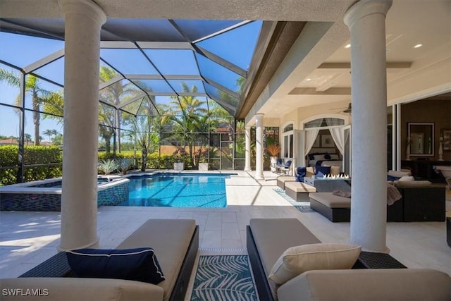 view of swimming pool with a pool with connected hot tub, a lanai, an outdoor hangout area, a patio, and a ceiling fan