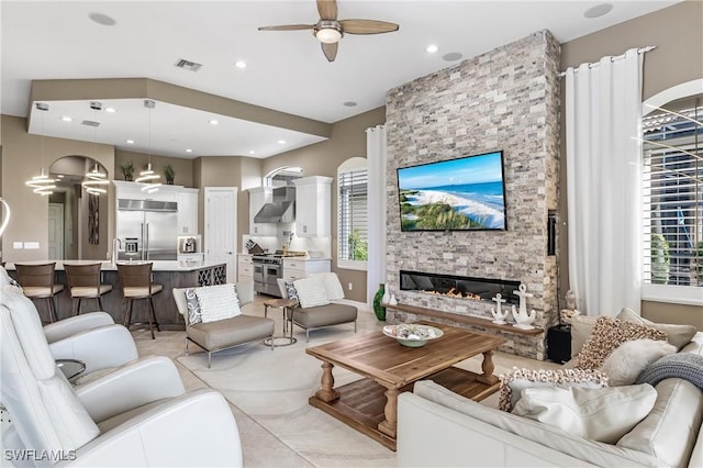 living room featuring a fireplace, recessed lighting, a ceiling fan, and visible vents