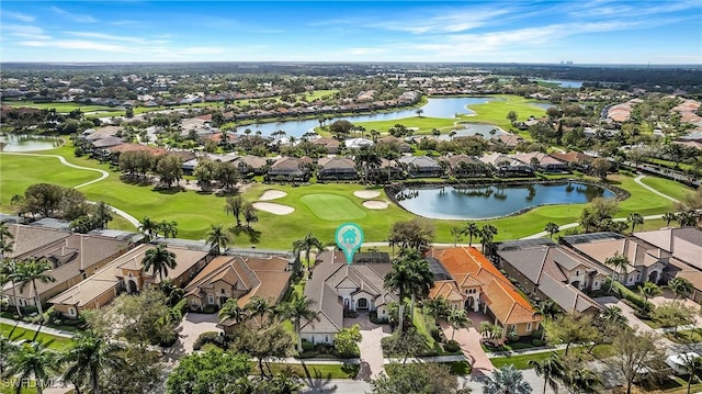 drone / aerial view with a residential view, golf course view, and a water view