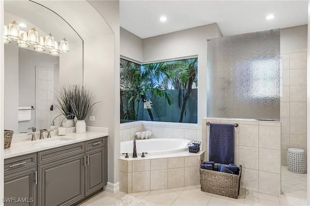 full bath featuring a garden tub, vanity, and tile patterned flooring