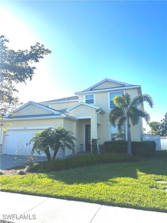 view of front of home with a front lawn, aphalt driveway, a garage, and stucco siding