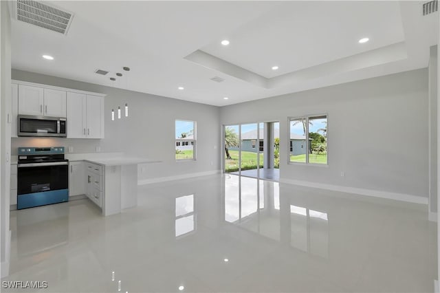 13224 Foresman Blvd, Port Charlotte, FL 33981 - kitchen featuring appliances with stainless steel finishes, open floor plan, a peninsula, white cabinetry, and light countertops