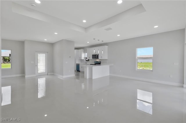13224 Foresman Blvd, Port Charlotte, FL 33981 - unfurnished living room with a raised ceiling, plenty of natural light, and recessed lighting