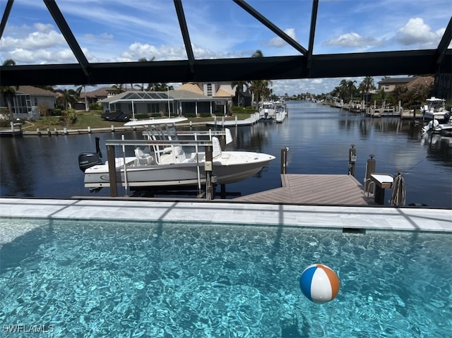 view of dock featuring glass enclosure, a water view, and boat lift