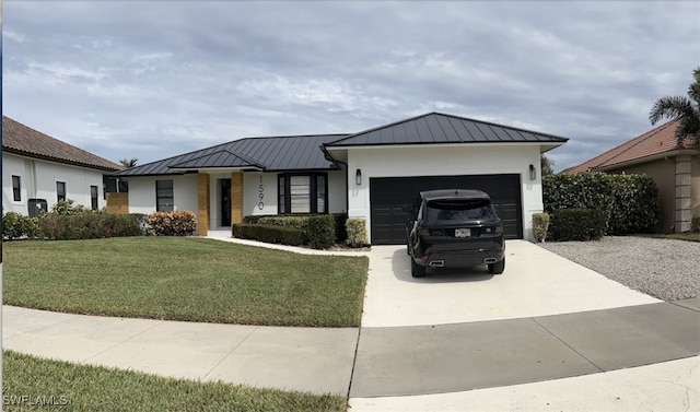 view of front of home with a garage, concrete driveway, metal roof, a standing seam roof, and a front yard