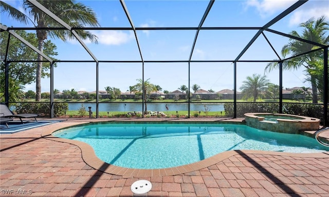 view of pool with glass enclosure, a pool with connected hot tub, a patio area, and a water view