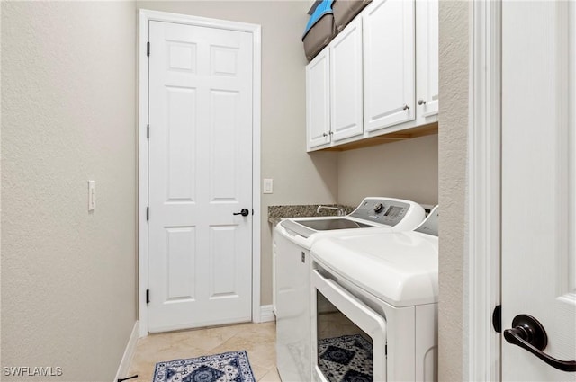 laundry area featuring cabinet space, light tile patterned floors, baseboards, and separate washer and dryer