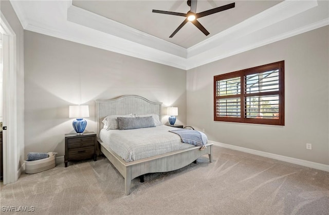 bedroom with carpet floors, baseboards, and a raised ceiling