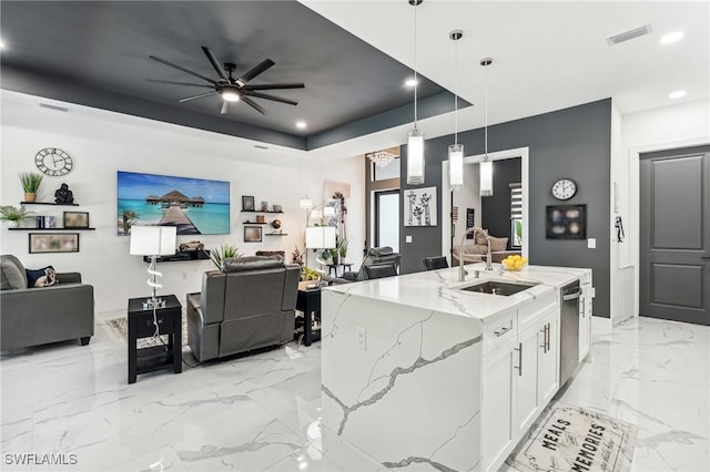 kitchen featuring a tray ceiling, marble finish floor, visible vents, open floor plan, and a sink