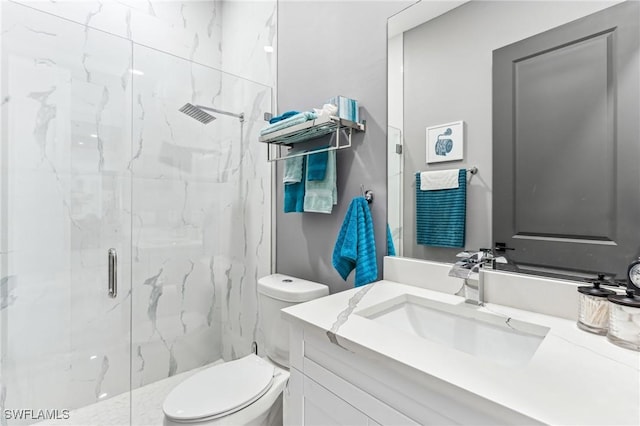 full bath featuring vanity, a marble finish shower, and toilet