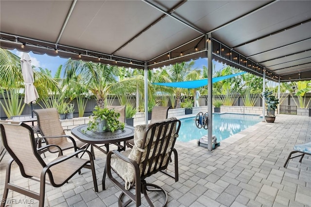 view of swimming pool featuring a fenced in pool, a patio area, a fenced backyard, and outdoor dining area