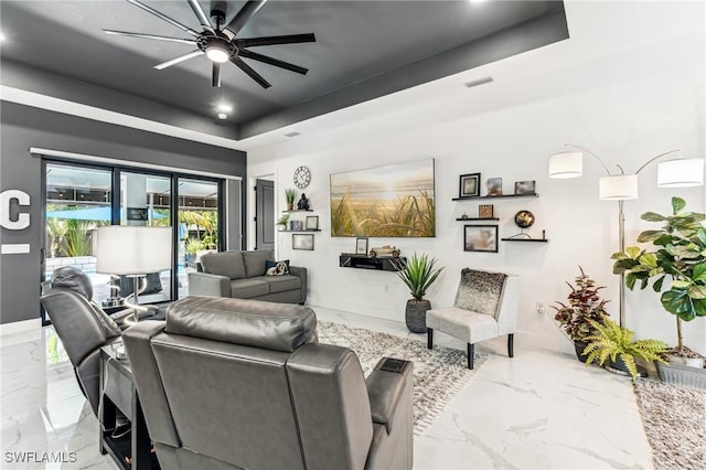 living room featuring visible vents, baseboards, ceiling fan, marble finish floor, and a tray ceiling