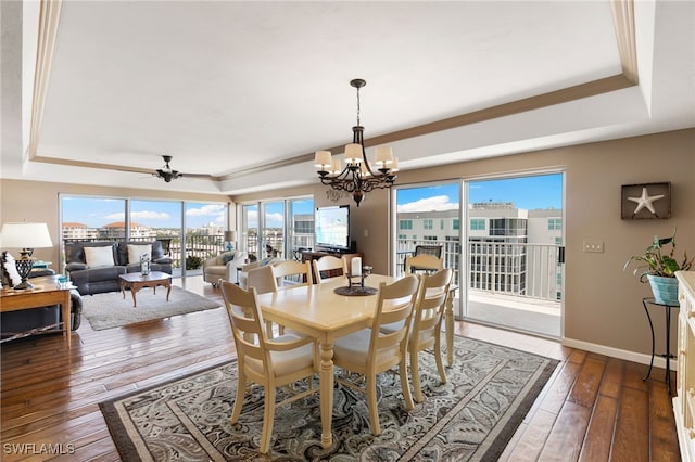 dining area with a tray ceiling, plenty of natural light, hardwood / wood-style floors, and ornamental molding