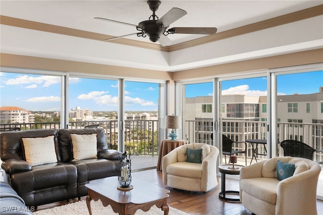 living room with a city view, ornamental molding, ceiling fan, and hardwood / wood-style floors