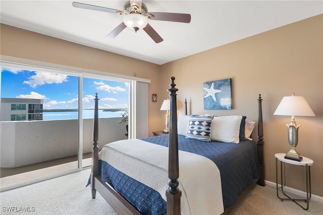 bedroom featuring baseboards, carpet, a water view, a ceiling fan, and access to outside