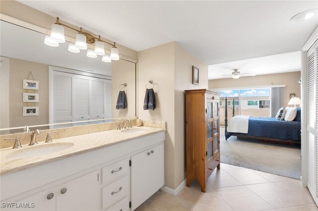 ensuite bathroom featuring a ceiling fan, ensuite bath, double vanity, and a sink