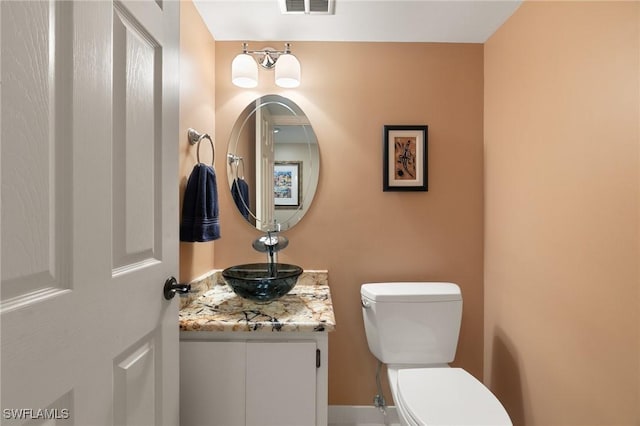 bathroom featuring visible vents, toilet, and vanity